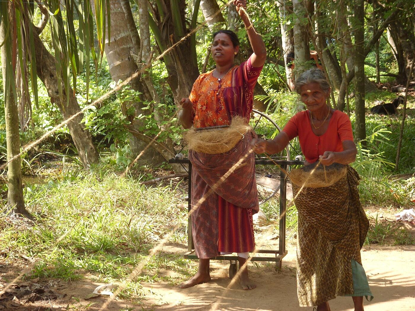 Women spinning coconut coir into rope on a hand wheel