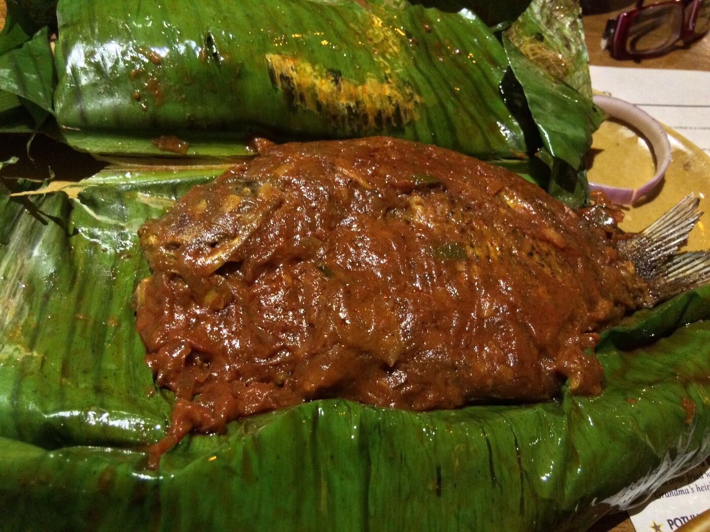 Karimeen pollichathu, pearlspot fish cooked in a charred banana leaf